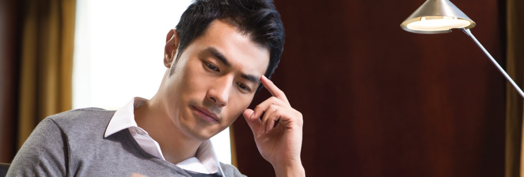 Un homme Asiatique qui regarde le journal