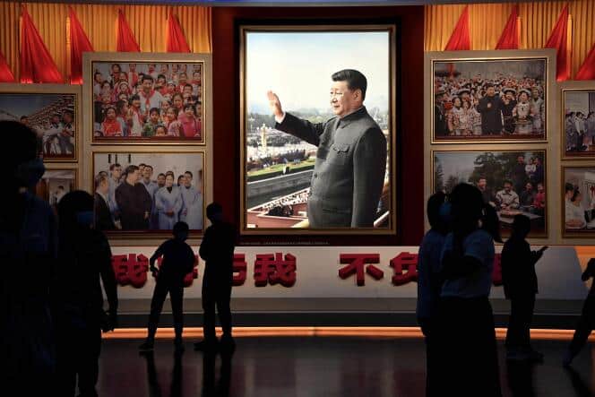 (FILES) In this file photo taken on September 4, 2022, people stand in front of images of China's President Xi Jinping at the Museum of the Communist Party of China in Beijing. China's President Xi Jinping is widely expected to secure a third term as president at the Chinese Communist Party congress meeting starting on October 16, 2022, upending the succession norms that Chinese leaders have abided by since the 1990s.  (Photo by Noel CELIS / AFP)