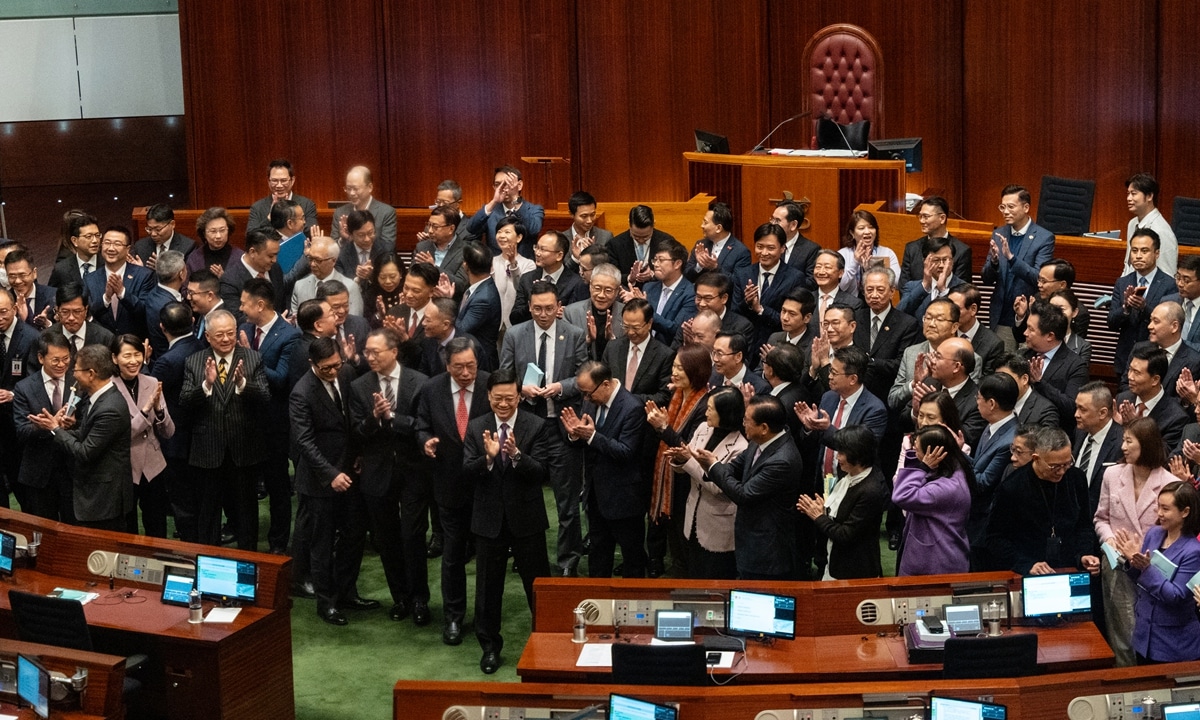 John Lee, Hong Kong's chief executive, front center, applauses with lawmakers following the passing of Basic Law Article 23 legislation at the Legislative Council in Hong Kong, China, on Tuesday, March 19, 2024. Hong Kong has fast-tracked into law a domestic security legislation that critics say could muzzle open economic discussion and tighten control over foreign bodies operating in the global finance hub. Photographer: Chan Long Hei/Bloomberg via Getty Images