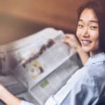 Une jeune femme chinoise qui regarde les journaux