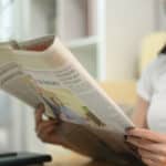 Une femme asiatique qui regarde le journal